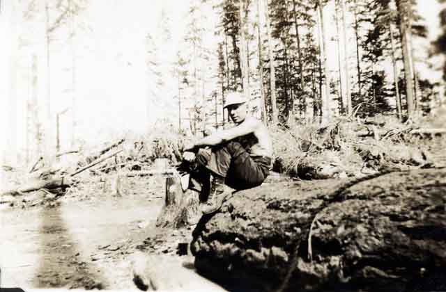 William Coopsie assis sur une grume.